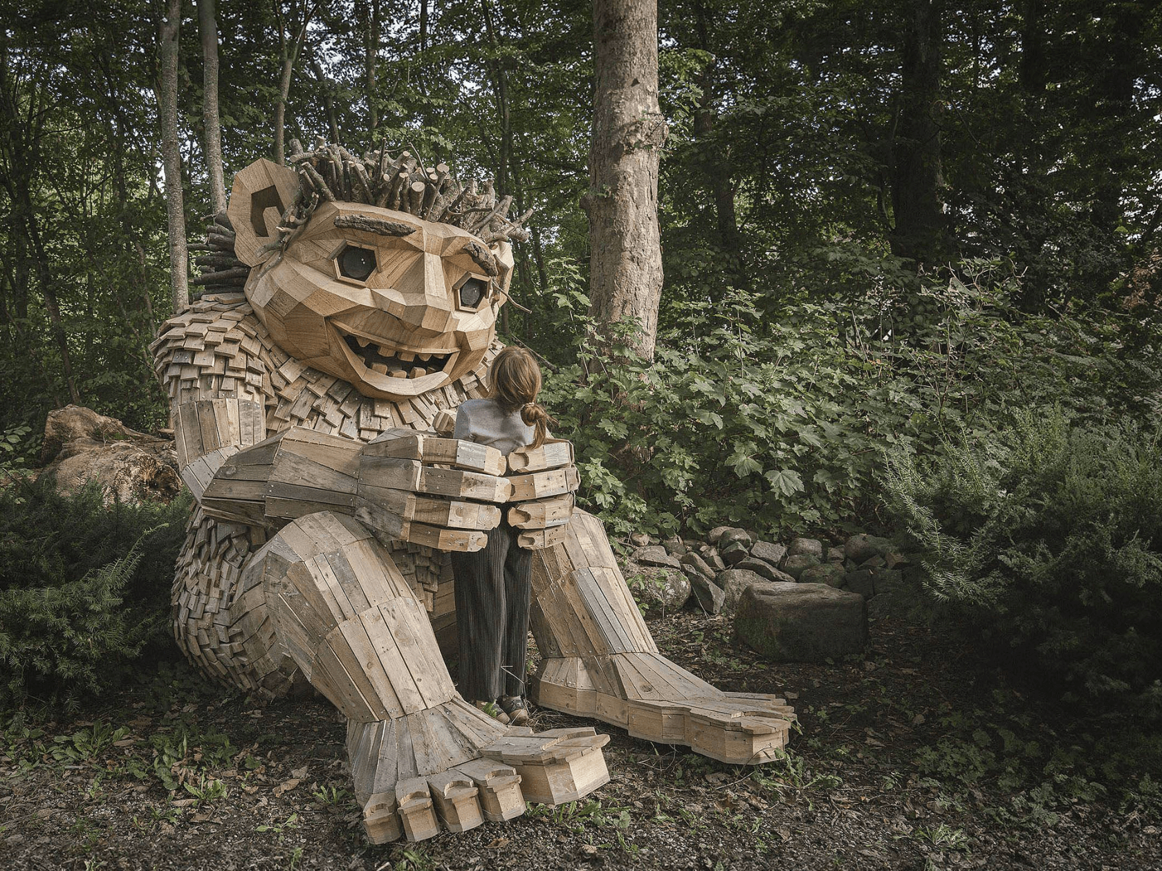 A troll statue made out of wood appearing to hold a pateron
